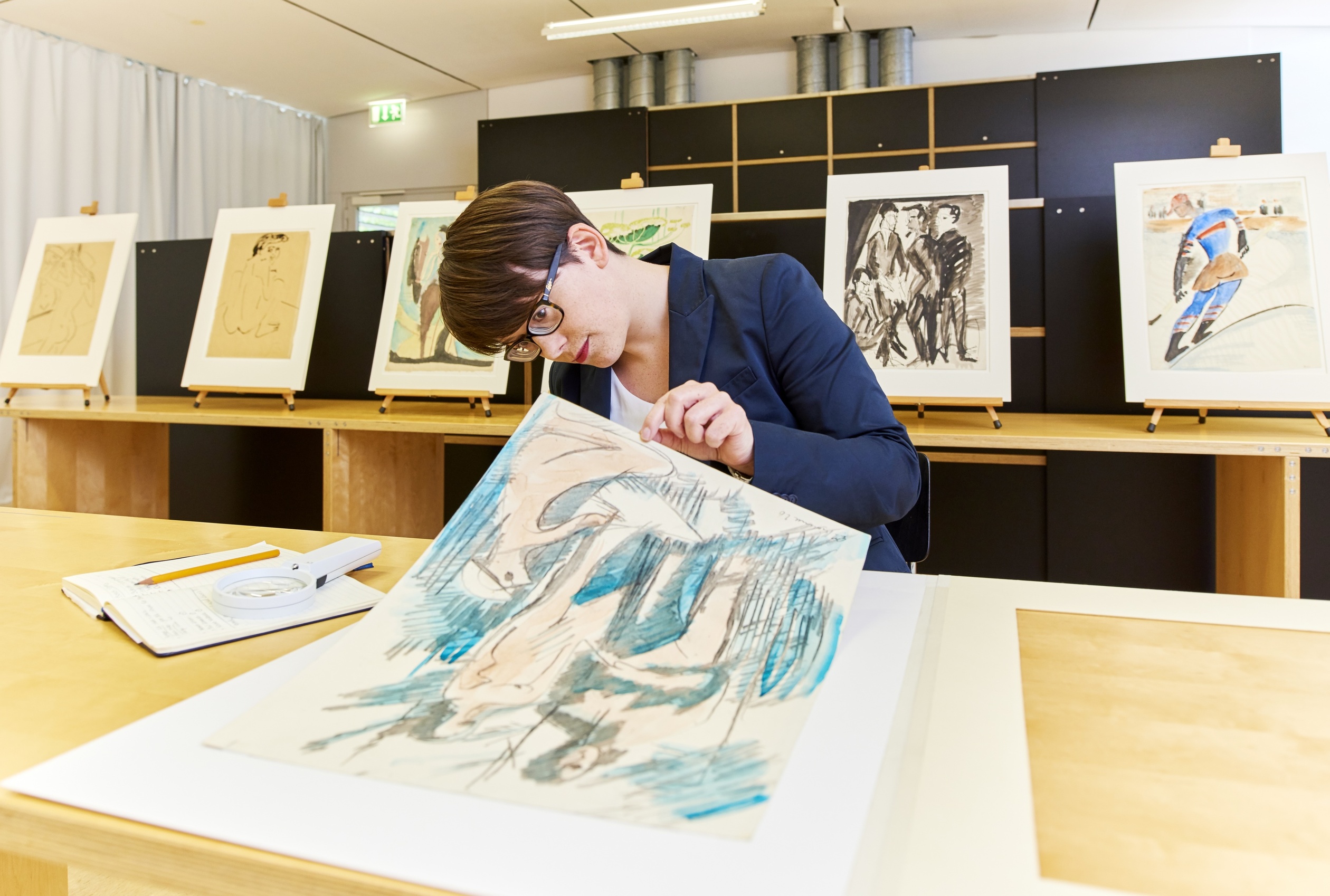 Sandra-Kristin Diefenthaler untersucht das Blatt »Drei Akte im Tannendickicht«, 1926, Kohle und Aquarell auf gelblichem, dünnen Karton, 46,2 x 34,8 cm, Staatsgalerie Stuttgart. (Bildquelle: Staatsgalerie Stuttgart, Presse, 2016)